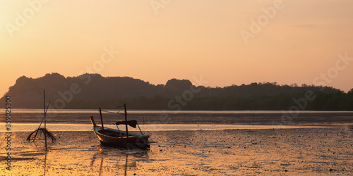 Seashore in the moment of sunset is surrounding by Thailand taxi boats.
