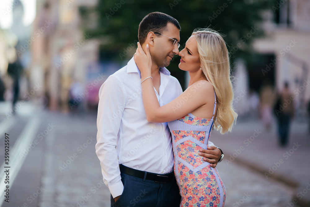 Fototapeta premium walking down the street together. Happy young man and smiling woman walking through the streets of Old Town,