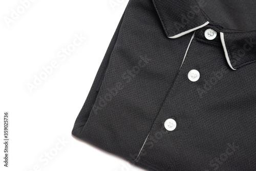 Folded blank black polo shirt with three white buttons. Polo shirt isolated on white background. Men's clothing.Folded clothes.