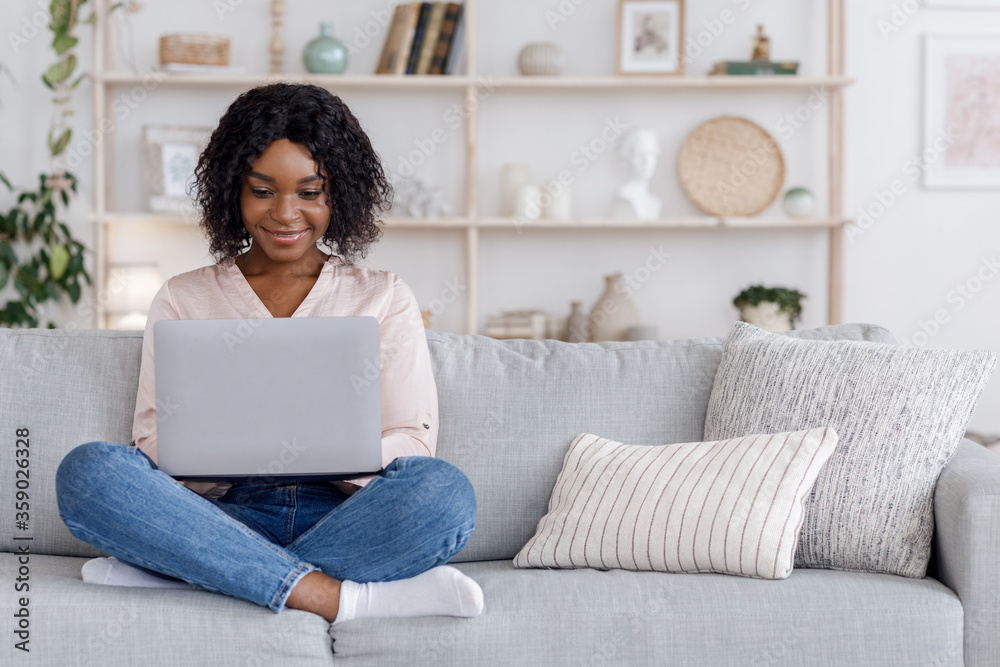 Freelance Concept. Black Woman Working On Laptop Computer On Couch At Home