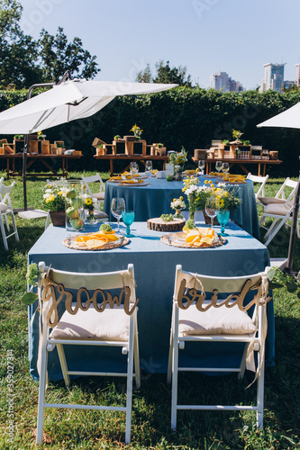 Banquet table setting and decoration. Cutlery on the table. Blue interior decoration. Tables at the outdoors. 