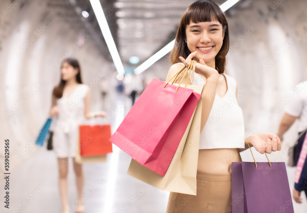 Asain woman in shopping. Happy woman with shopping bags enjoying in shopping.lifestyle concept.Smiling girl holding colour paper bag.Friends walking in shopping mall. Asain woman in shopping. Happy woman with shopping bags enjoying in shopping.lifestyle concept.Smiling girl holding colour paper bag.Friends walking in shopping mall.