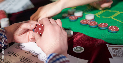 man prepare place bet with poker chips on green table