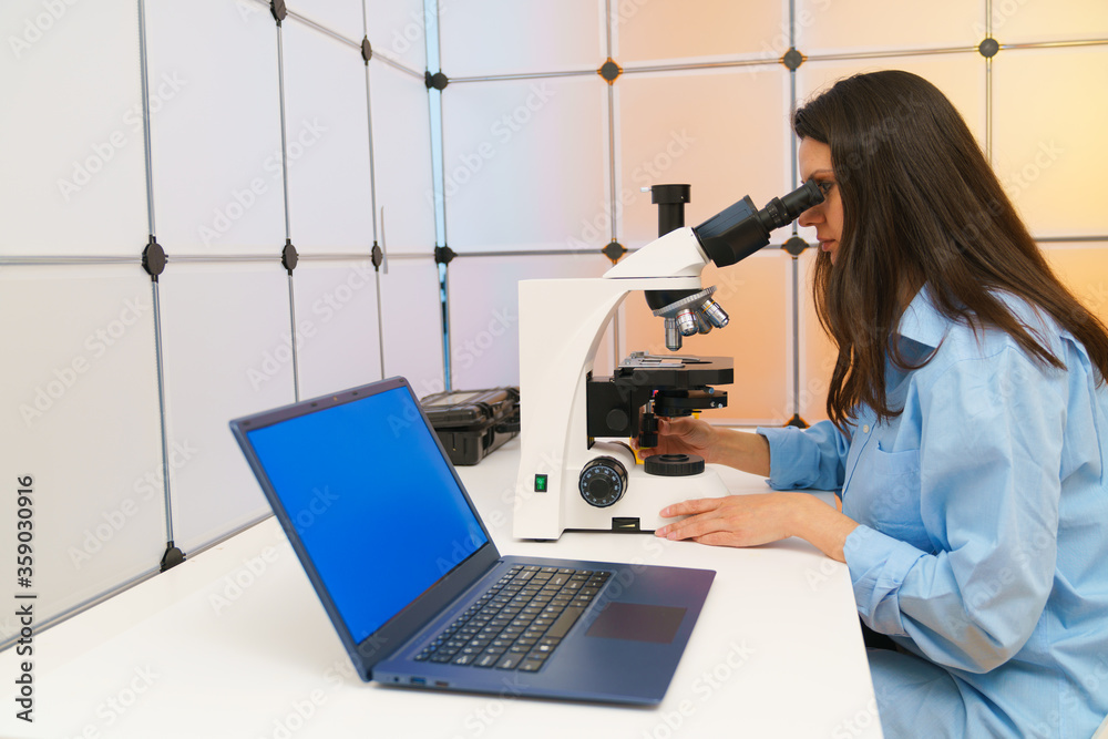 Young woman in a science lab. Health care researchers working in life science laboratory. Young woman in a science lab. Health care researchers working in life science laboratory.