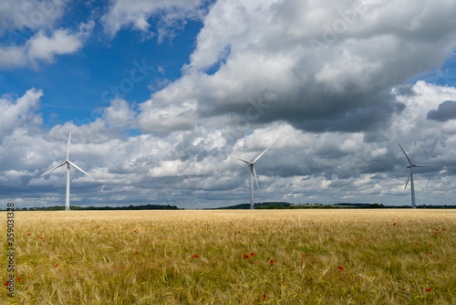 Photography of 3 wind turbines at a cloudy sky background during sunny day 