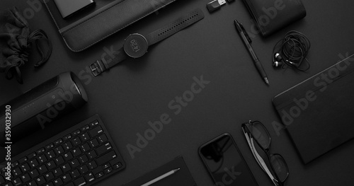 Business concept. Flat lay composition with various black gadgets on dark black surface photo