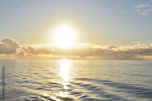 Atlantic ocean, calm sea under the sunset during summer time. Sun is behind the layer of the clouds. © Lucia