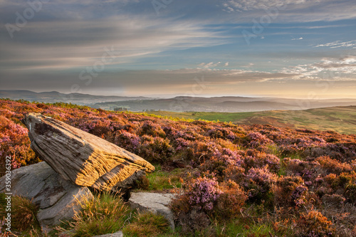 View of the landscape with a large rock in the foreground from the Simonside hills, near Rothbury, Northumberland, UK photo