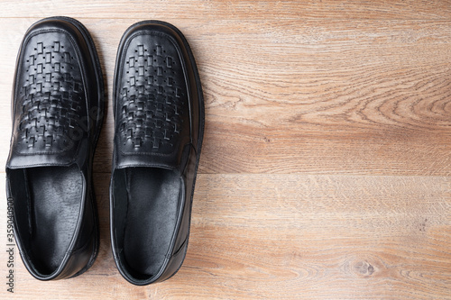 New black men shoes on wooden background. Elastic sided shoes. Side gusset shoes. Lazyman shoes. Top view. Copy space