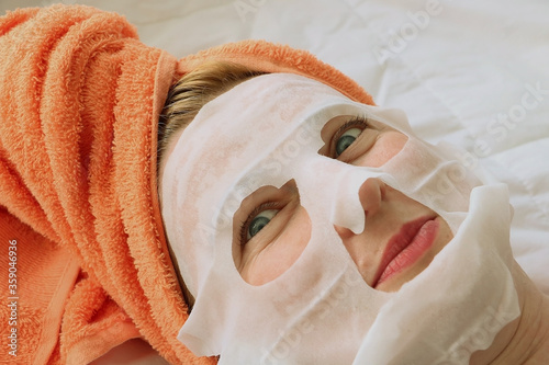 Young woman is relaxing at home. Home spa. Face mask and hair procedures.