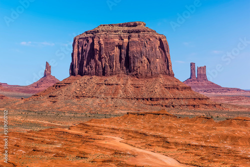 A dominant view of Merrick Butte with East Mitten and West Mitten Buttes behind in Monument Valley tribal park in springtime