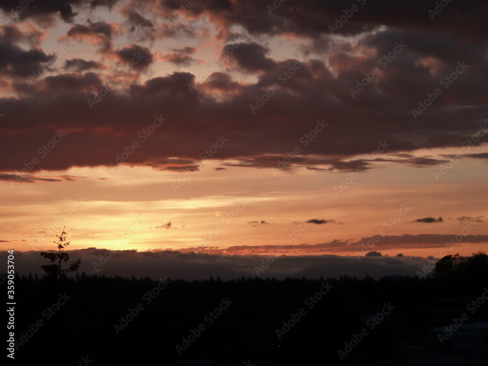 Dramatic sky over Northwest Cascade Range during sunrise hours on a spring day on Mercer Island in Washington State.