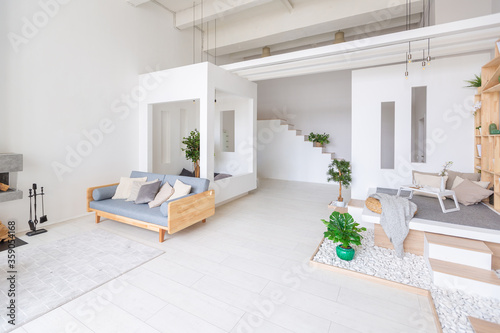 Luxury fashionable modern design studio apartment with a free layout in a minimal style. very bright huge spacious room with white walls and wooden elements. sitting area with fireplace