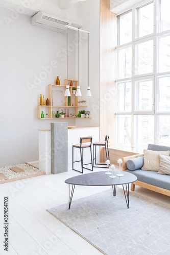 Luxury fashionable modern design studio apartment with a free layout in a minimal style. very bright huge spacious room with white walls and wooden elements. sitting area with fireplace