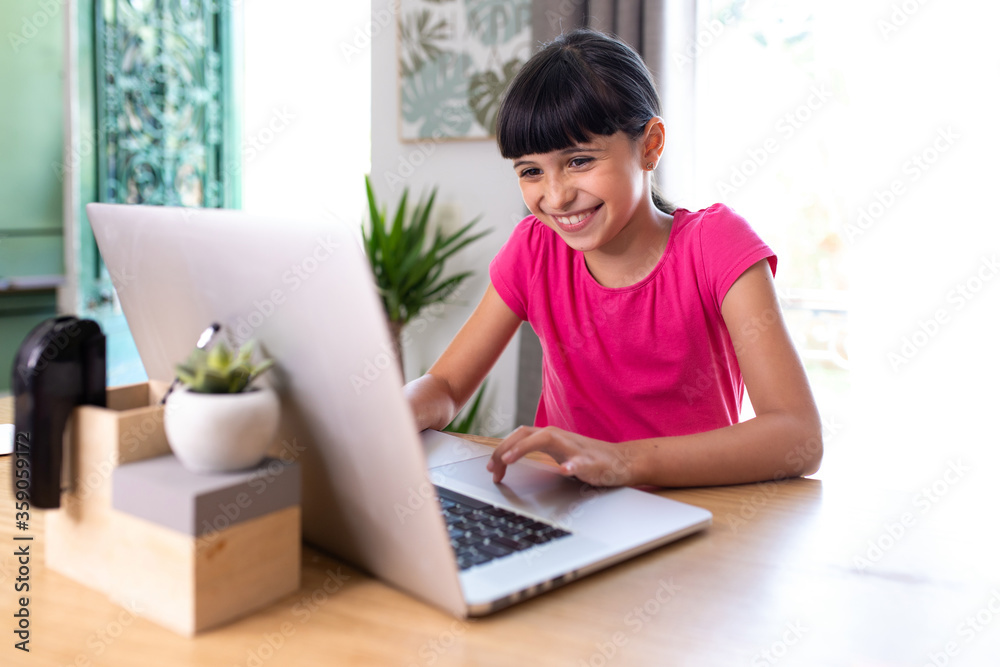 smiling girl at home who works on a computer like a grown-up