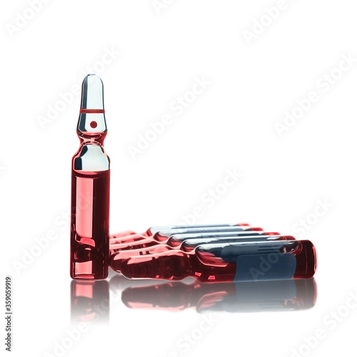 A group of medicine ampoules with red liquid inside with reflection isolated on white
