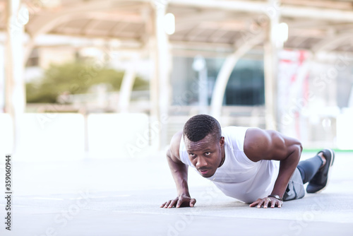 african american man is outdoor exercising by push up Look strong, clearly see the muscles in the upper arm © pornchai
