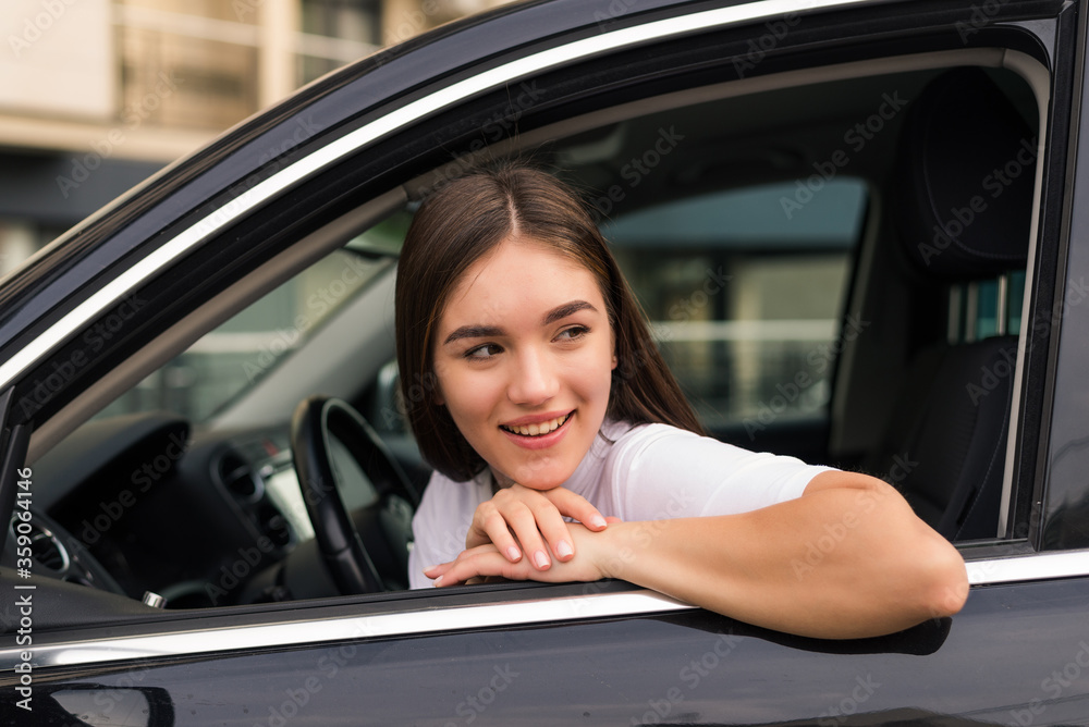 Young woman leaning her elbow over car window while enjoying road trip