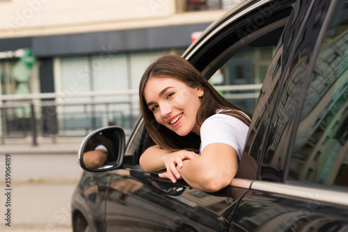 Relaxed happy woman on summer roadtrip travel vacation leaning out car window