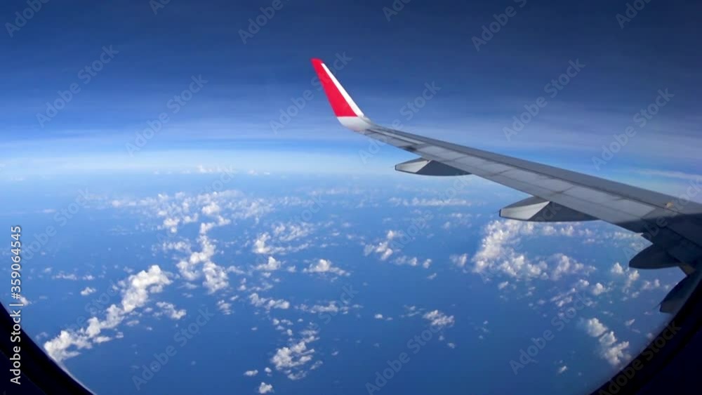 Looking through window aircraft during flight with a nice blue sky with clouds