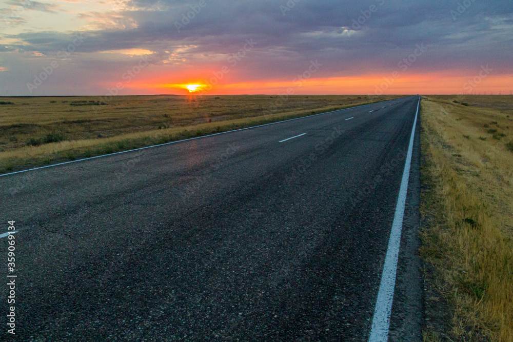 Naklejka premium Sunset view of a road in russian steppe