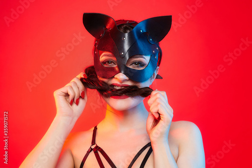 beautiful girl in a cat mask. playfully posing in front of the camera