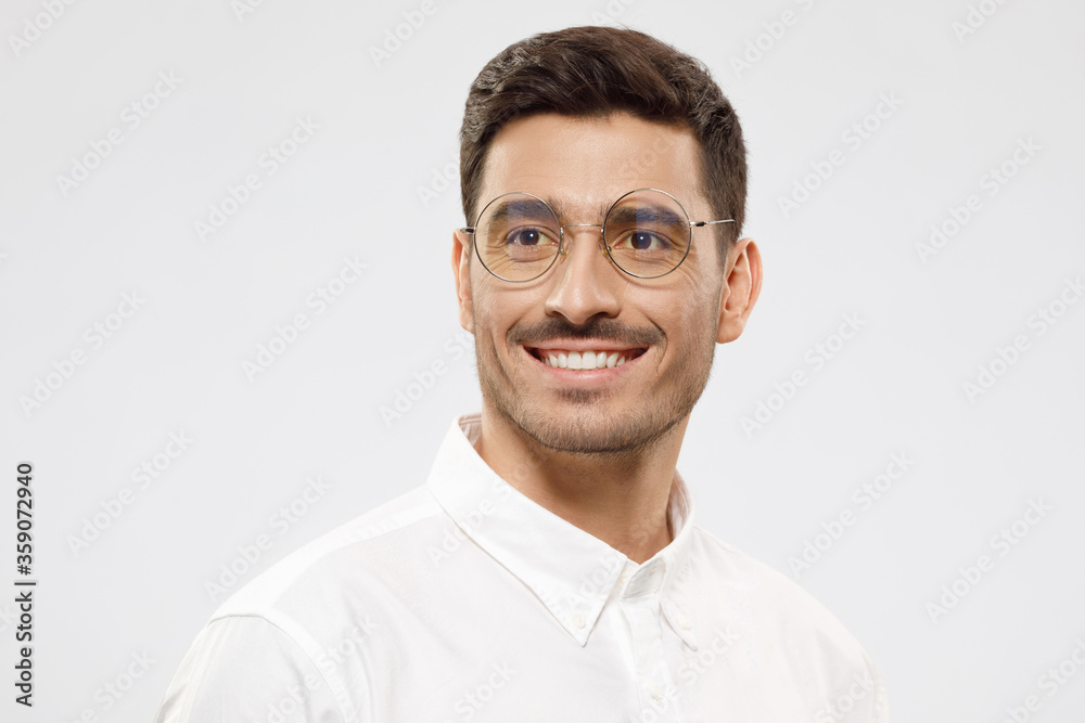 Young modern teacher wearing white formal shirt and glasses, looking aside as if thinking of future project, isolated on gray background Young modern teacher wearing white formal shirt and glasses, looking aside as if thinking of future project, isolated on gray background