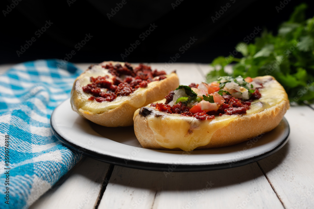Mexican molletes with chorizo and fresh sauce on white background Mexican molletes with chorizo and fresh sauce on white background