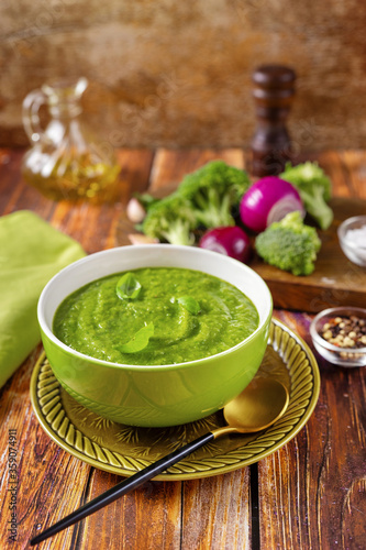 Vertical shot of vegan green broccoli soup on trendy red orange background