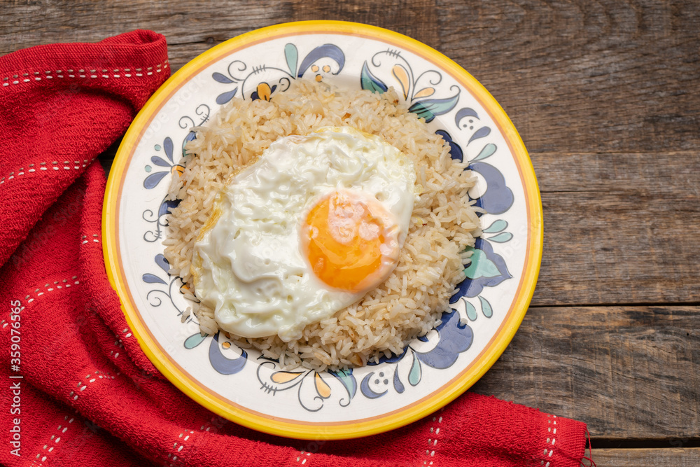 Fried egg with rice on wooden background Fried egg with rice on wooden background