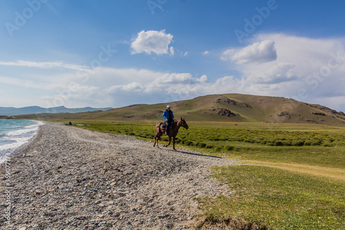 SONG KUL, KYRGYZSTAN - JULY 23, 2018: Horse rider near Song Kul lake, Kyrgyzstan