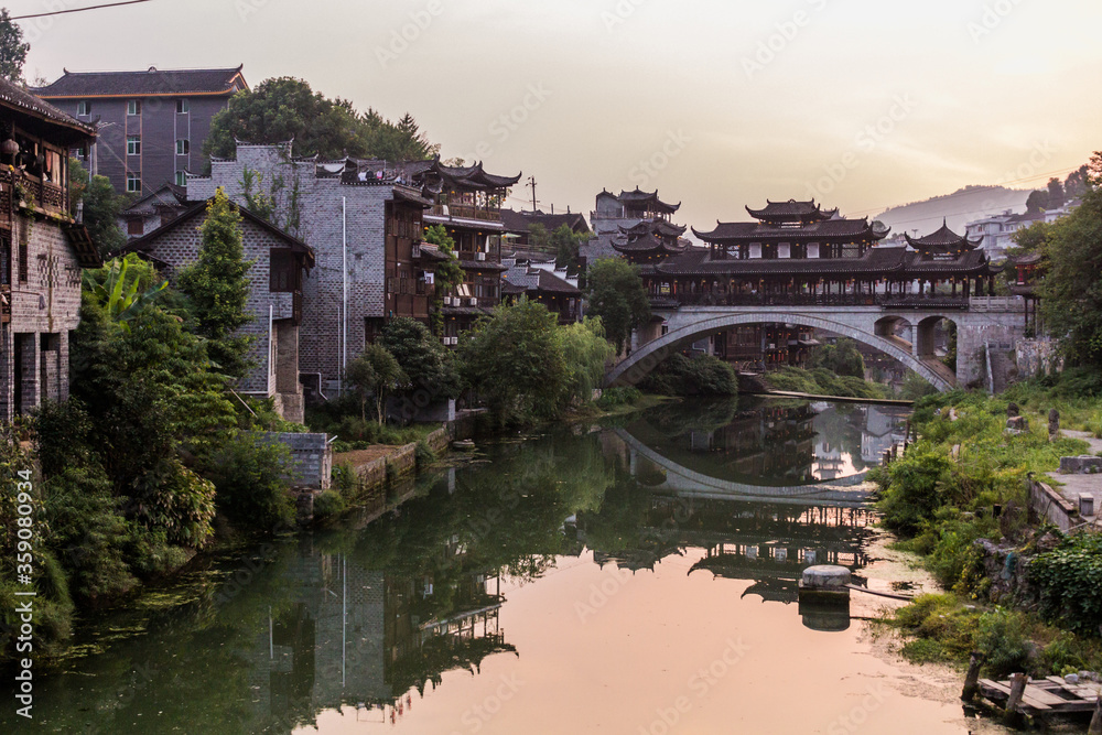 Old bridge reflecting in a river in Furong Zhen town, Hunan province, China