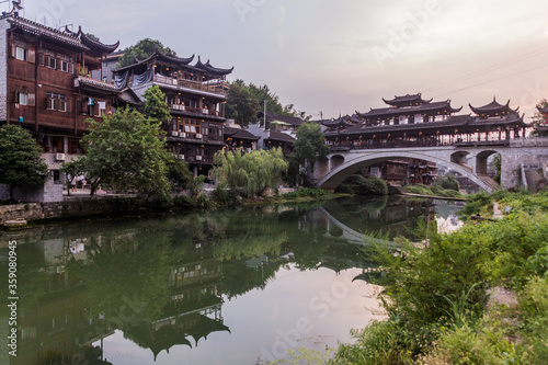 Old bridge reflecting in a river in Furong Zhen town, Hunan province, China