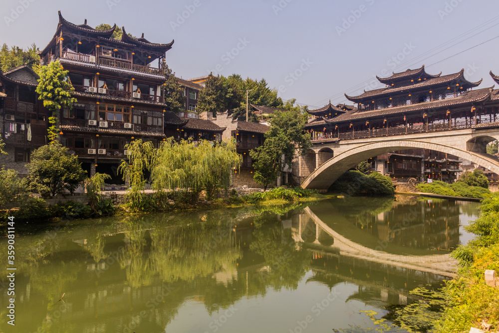 Bridge reflecting on a river in Furong Zhen town, Hunan province, China