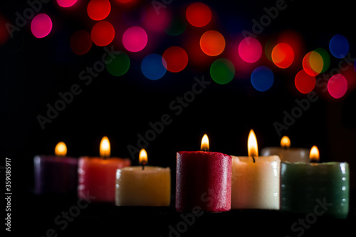 colorful candles lit at twilight with colorful bokeh background