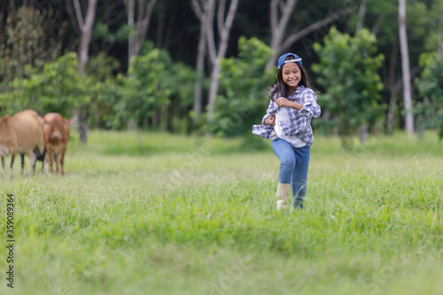 A cute Asian girl is running happily in the fields in her farm.