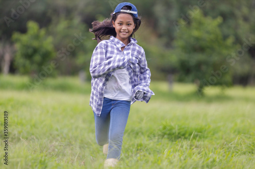 A cute Asian girl is running happily in the fields in her farm.