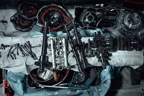 Disassembled fast motorcycle engine with visible transmission, locking valve, gear and piston parts. Sixteen valves and four cylinder motor.