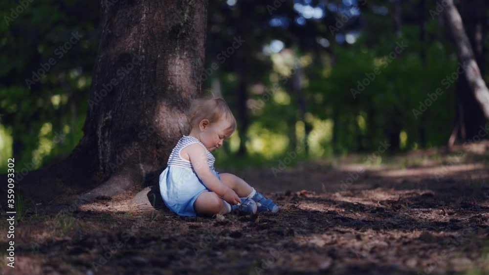 the curiosity and interest of children, a child sitting on the ground studying, examines the forest soil the curiosity and interest of children, a child sitting on the ground studying, examines the forest soil