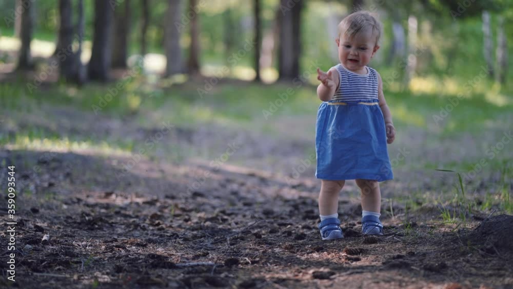 one year old baby learned to walk. little girl runs in the park alone one year old baby learned to walk. little girl runs in the park alone