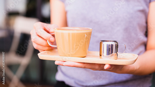 woman holding a cup of coffee serving to customer