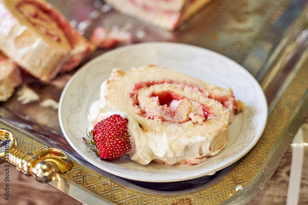 Cutting freshly baked sweet strawberry Long-Cake Roll, also called Strawberry roulade Cutting freshly baked sweet strawberry Long-Cake Roll, also called Strawberry roulade