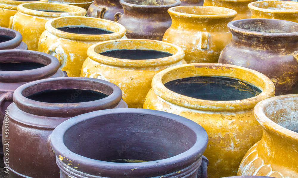 rows of large colorful distressed Mexican clay pottery rows of large colorful distressed Mexican clay pottery