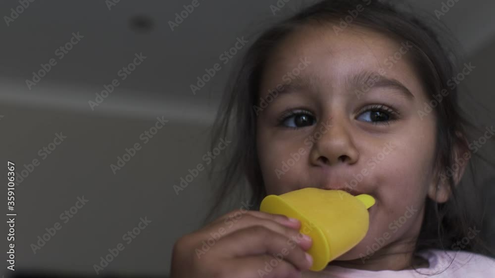 Little Four Year Old UK Asian Girl Eating Ice Lolly. Low Angle, Locked Off