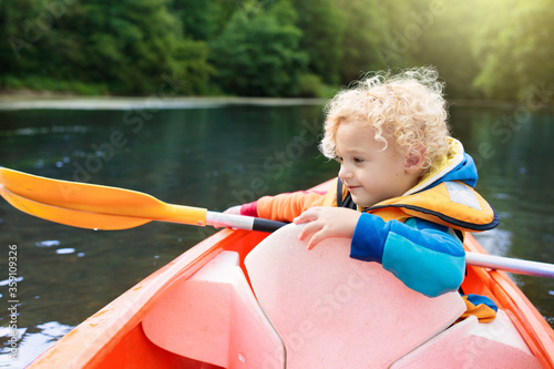 Child on kayak. Kids on canoe. Summer camping.