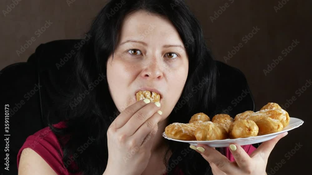 Woman eating cake.Girl eats eclairs with condensed milk.Tastes sweet dessert. Woman eating cake.Girl eats eclairs with condensed milk.Tastes sweet dessert.