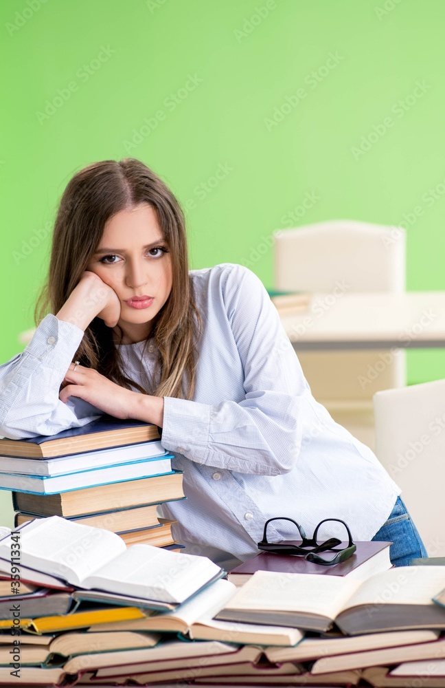 Young female student preparing for exams with many books Young female student preparing for exams with many books