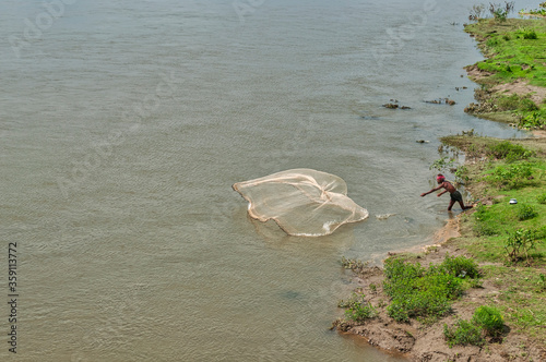 River Dhepa in Kantanagar, Dinajpur District, Bangladesh  – August 27, 2015 – a fisherman casts his fishing net in the waters of River Dhepa photo