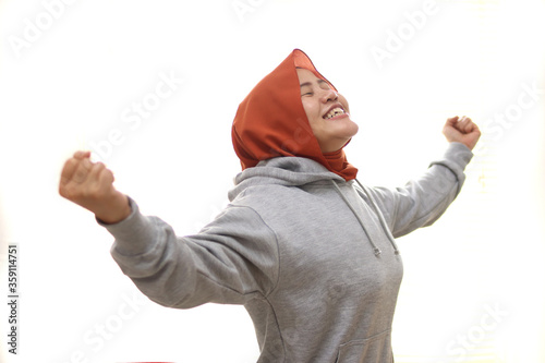 Beautiful Asian muslim woman wearing hijab feel relieve, fresh air, winning gesture, happy xpressions