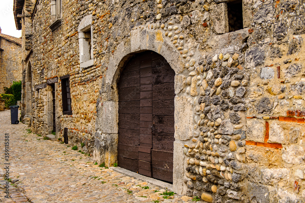 Fototapeta premium Narrow street in Perouges, France, a medieval walled town, a popular touristic attraction.